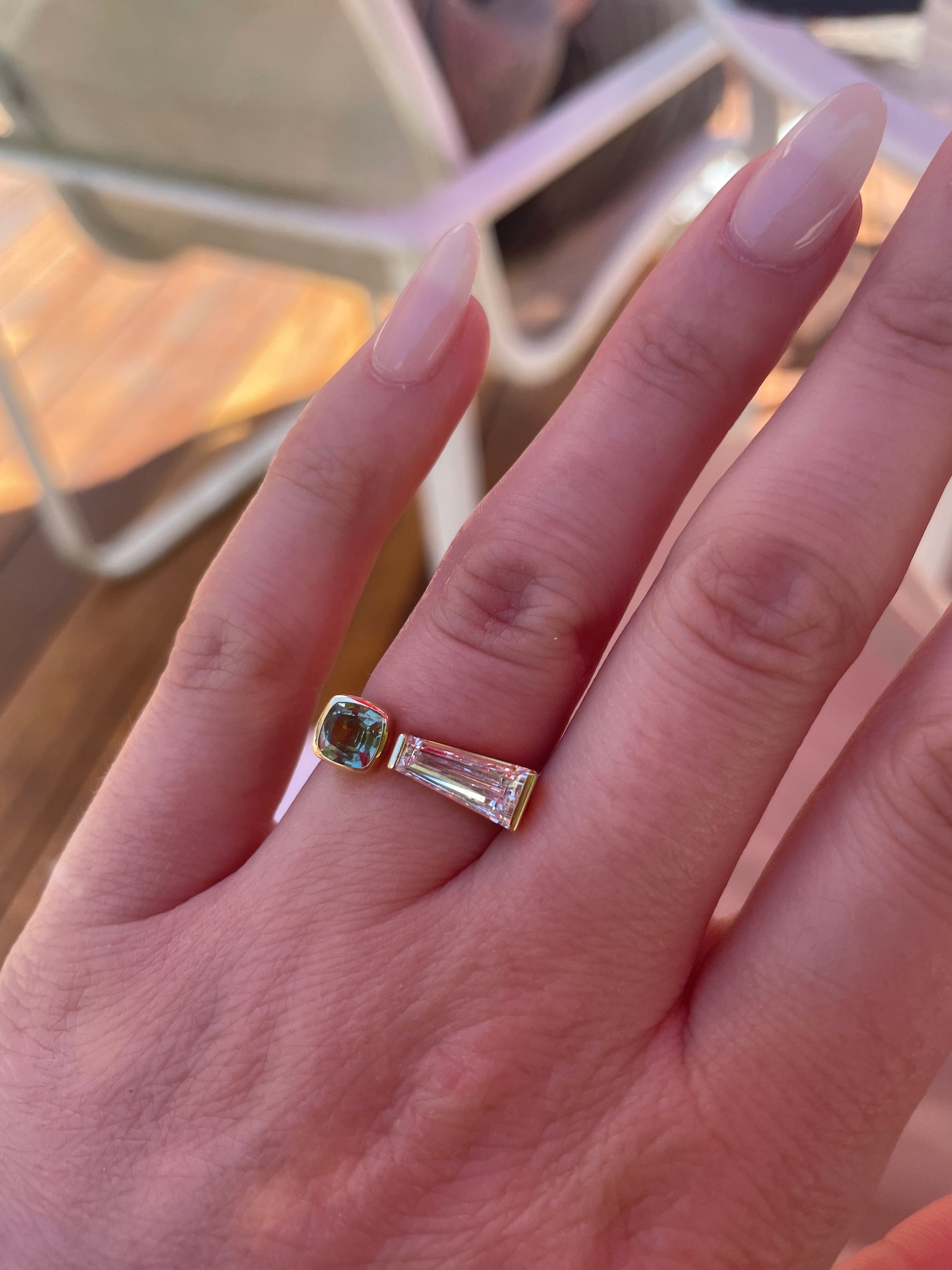 Closeup of tapered baguette diamond and sapphire ring on hand