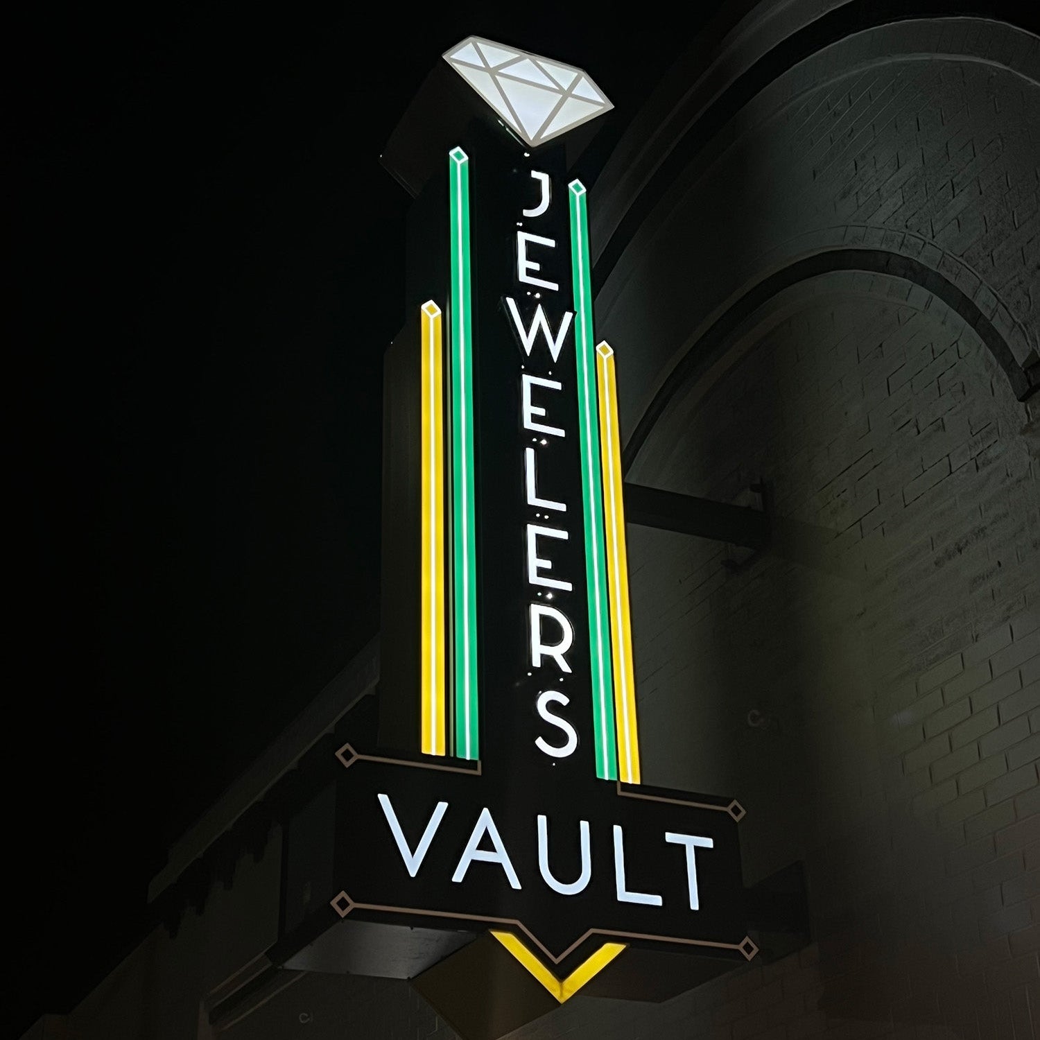 Neon sign for 'Jewelers Vault' on a dark background