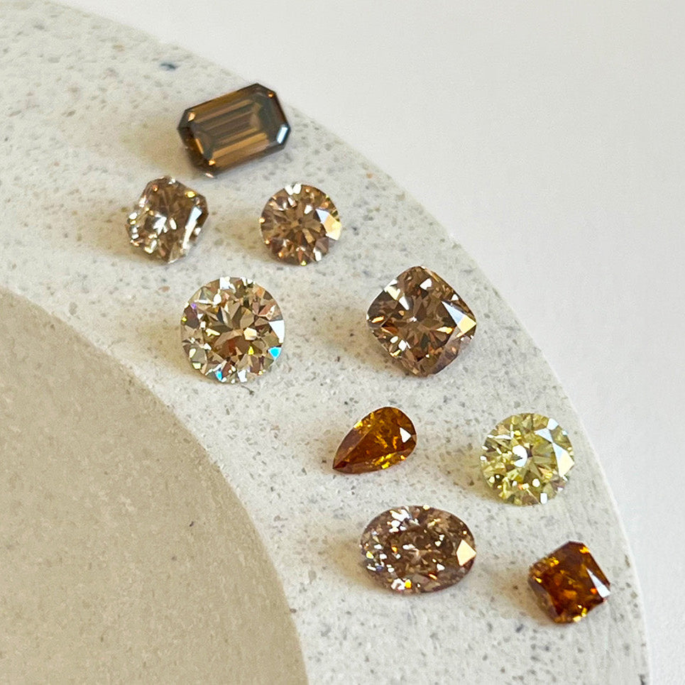 Varying colored diamonds on a stone tray.